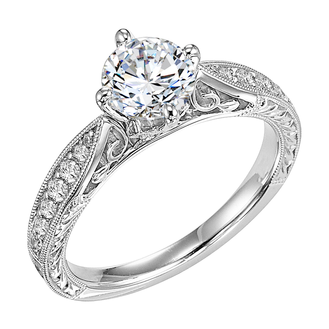 Masterfully crafted, this engagement ring dazzles with its round center stone and prong set diamond band with delicate milgrain and beautiful engraving