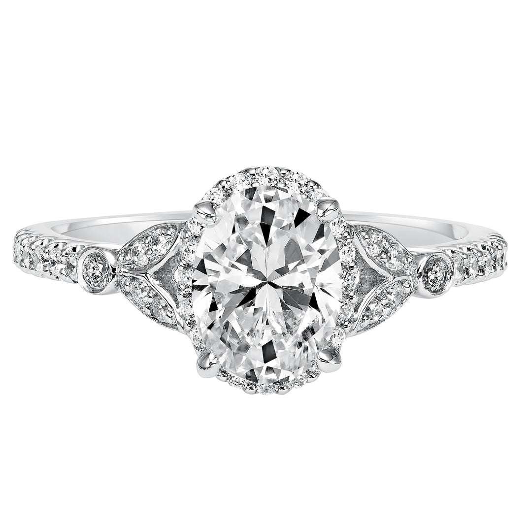 This romantic and beautiful engagement ring features an oval cut diamond accentuated by a prong set diamond halo and petal-inspired band design