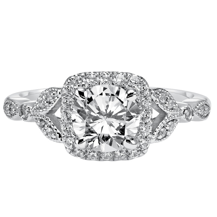 This whimsically styled engagement ring sparkles with its filigree and diamond halo and diamond prong set floral-inspired band